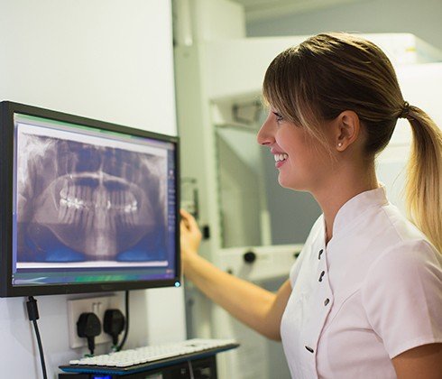 Dental team member looking a digital x-rays