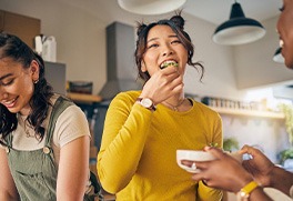 a woman eating food at a gathering with friends