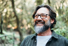 smiling man with glasses on a hike