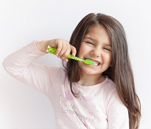 Girl brushing teeth at home after children's dentistry visit