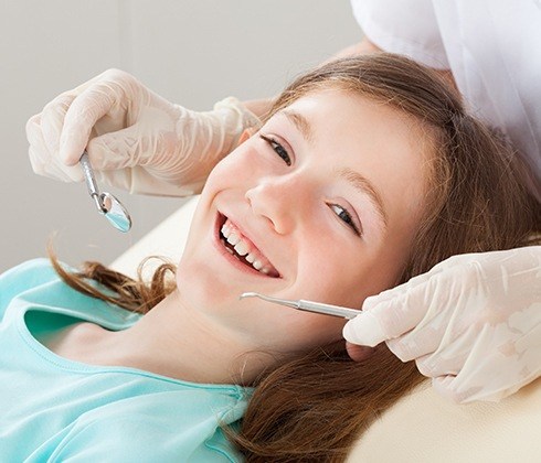 Young girl smiling during dental treatment