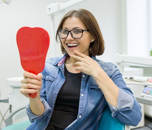 Woman looking at her smile after teeth whitening