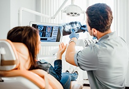 a dentist showing his patient her X-rays