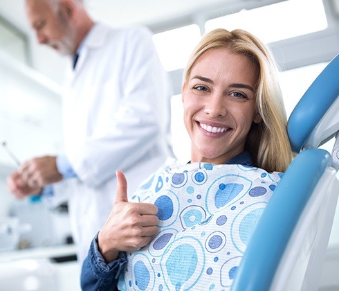 Woman giving thumbs up after emergency dentistry