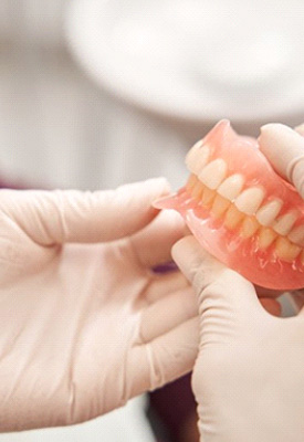 Dentist holding dentures