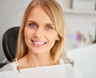 A portrait of a pleased and smiling woman in a dentist’s clinic