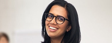 Woman with glasses smiling after T M J therapy