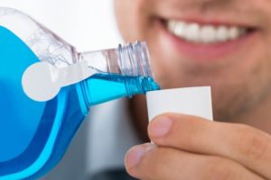 A person pouring mouthwash.