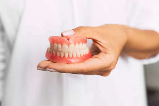 dentist holding dentures in hand 