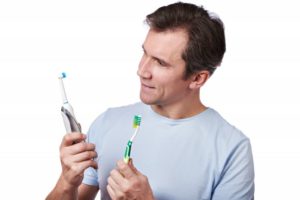 A man compares toothbrushes.