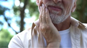 Distressed man holding his jaw in pain