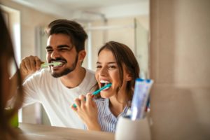 Couple brushing their teeth with tips from a dentist