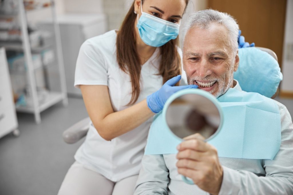 Dental professional showing patient how to care for dental implant