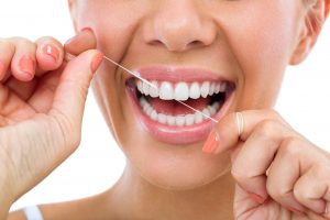 Closeup of woman smiling and flossing