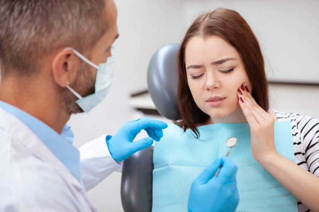 Woman with toothache visiting emergency dentist
