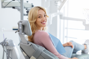 a smiling woman sitting in a dental chair