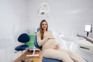 a pregnant patient sitting in a dental chair