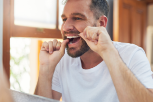a man flossing his teeth